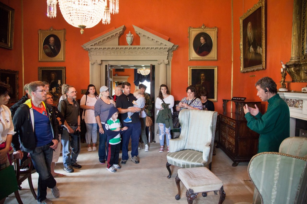 Tour guide talking to a group of visitors in a historic room in malahide castle
