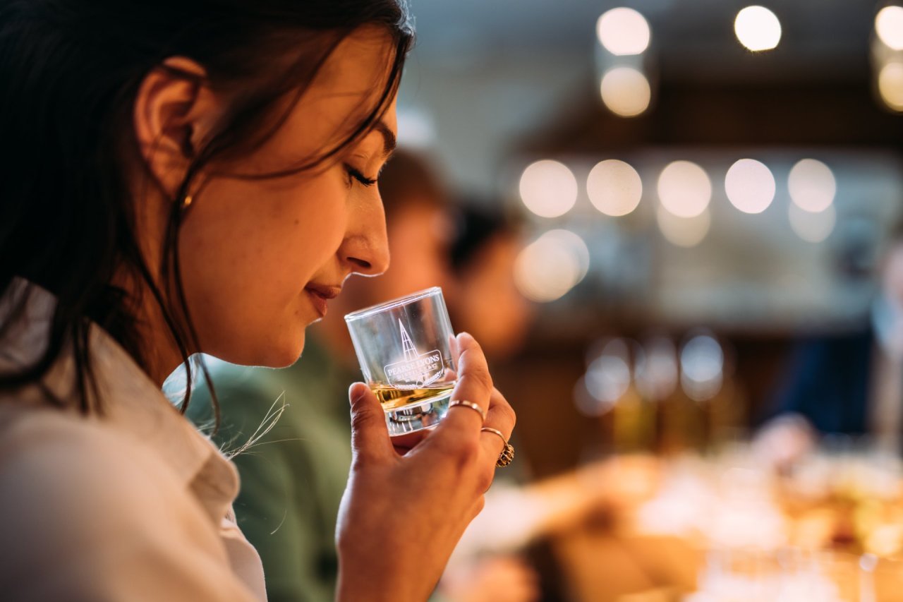 woman sniffing a glass of whiskey